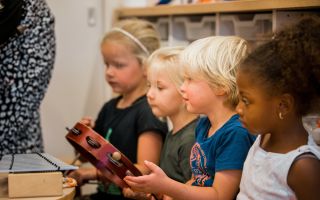Muziekakkoord Drenthe - Kinderen die aandachtig kijken en instrumenten beet hebben.